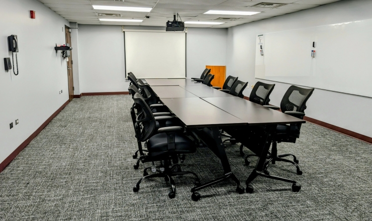 Mary Nelson Room - Board Room Style set up with large screen and white boards